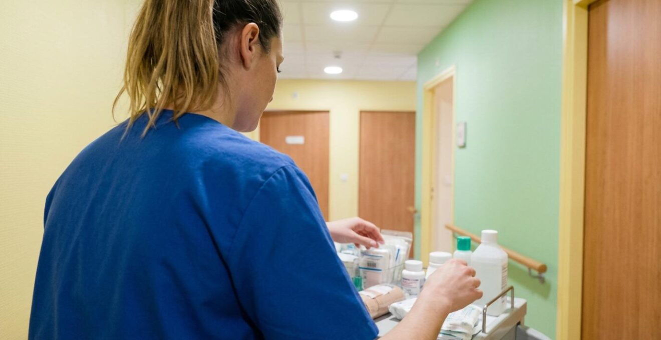 Aide-soignante préparant le chariot de soins dans un couloir d'EHPAD