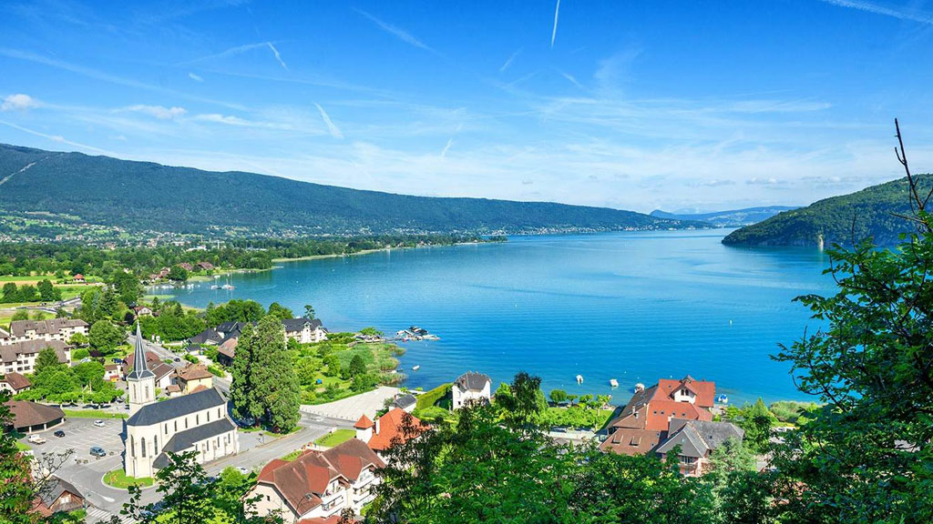 Famille européenne en pause vélo au bord du lac d'Annecy avec vue alpine