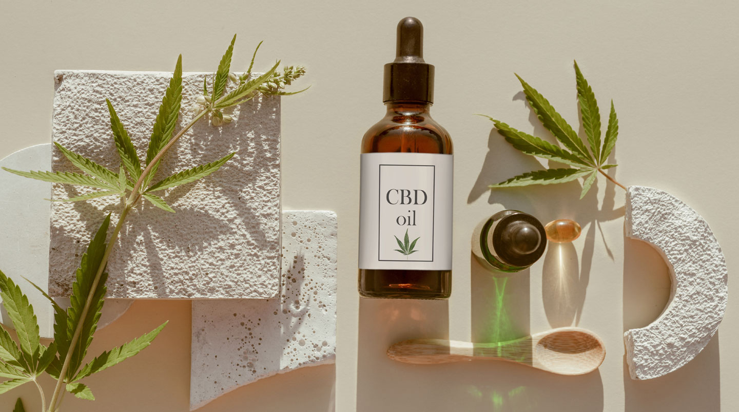 Personne adulte examinant attentivement l'étiquette d'un produit CBD dans un cadre naturel lumineux